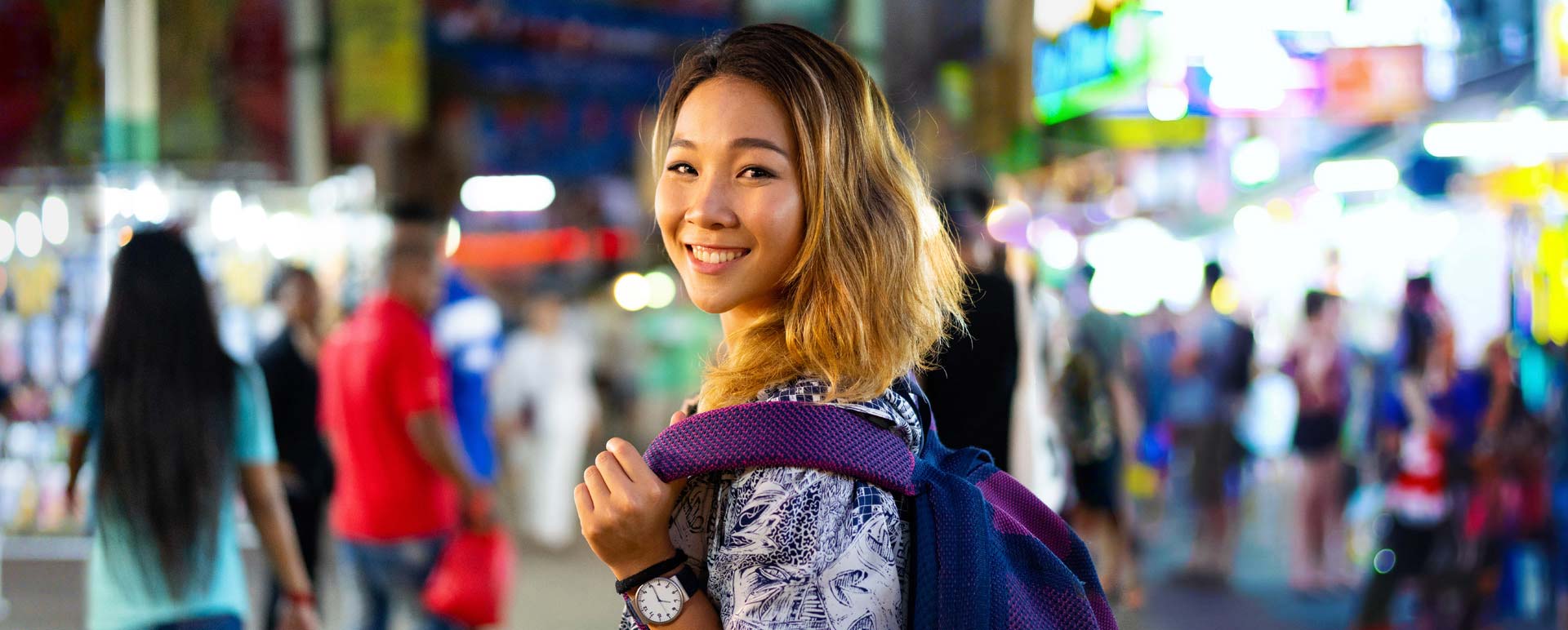 Happy Young Asian student girl exploring a night market.