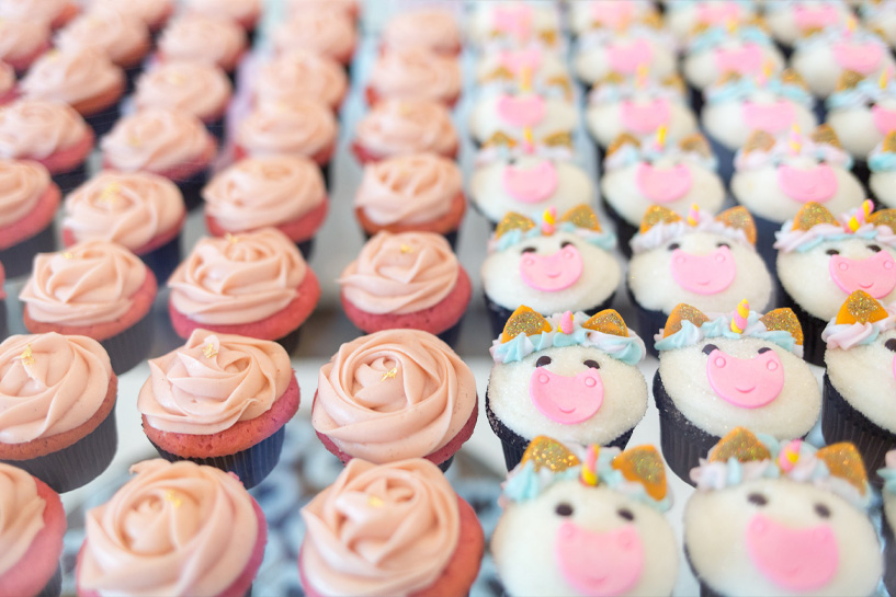 Cupcakes with pink rose and cute pig face frosting designs.